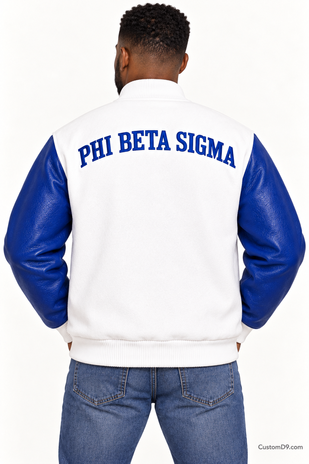 Black man modeling Phi Beta Sigma premium contrast varsity jacket with white body and royal blue sleeves, back view.