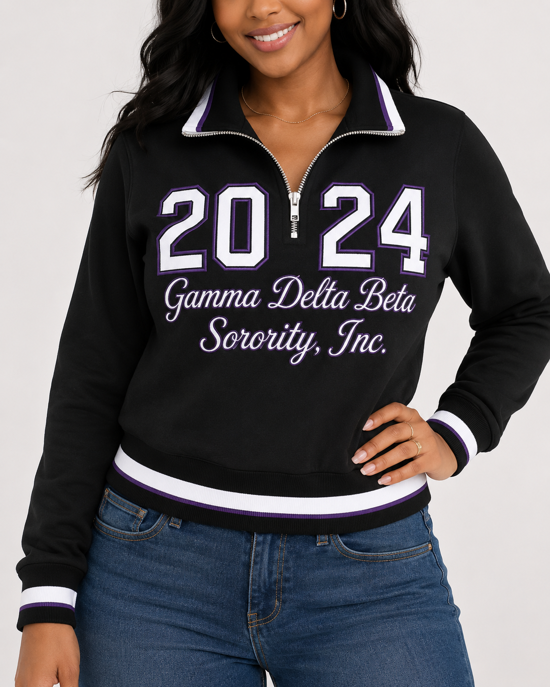 Model wearing a black Gamma Delta Beta quarter-zip pullover with purple and white trim and 2024 front design