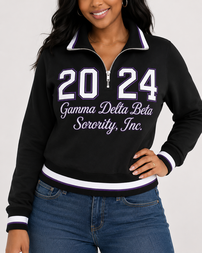 Model wearing a black Gamma Delta Beta quarter-zip pullover with purple and white trim and 2024 front design