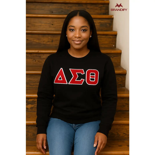 Model wearing a black Delta Sigma Theta sweatshirt with red and white ΔΣΘ chenille letters