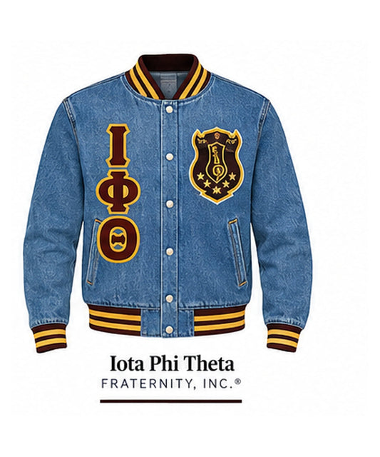 Medium-blue Iota Phi Theta full-denim varsity jacket with denim sleeves, brown and gold trim, crest, and stacked Greek letters