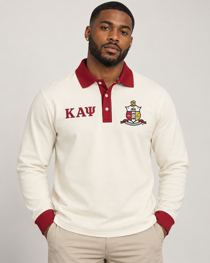 Kappa Alpha Psi man wearing cream long-sleeve polo with crimson collar, placket, cuffs, crest, and Greek letters