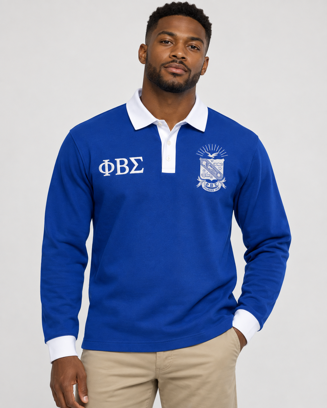 Phi Beta Sigma man wearing royal blue long-sleeve polo with white collar, placket, cuffs, crest, and Greek letters