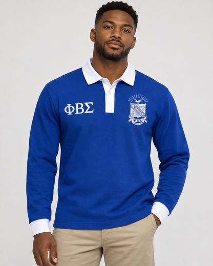 Phi Beta Sigma man wearing royal blue long-sleeve polo with white collar, placket, cuffs, crest, and Greek letters