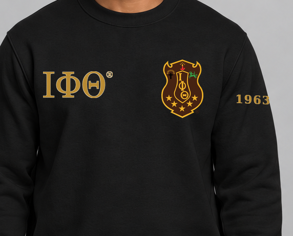 Iota Phi Theta premium embroidered black solid crewneck sweatshirt on model - chest embroidery close-up