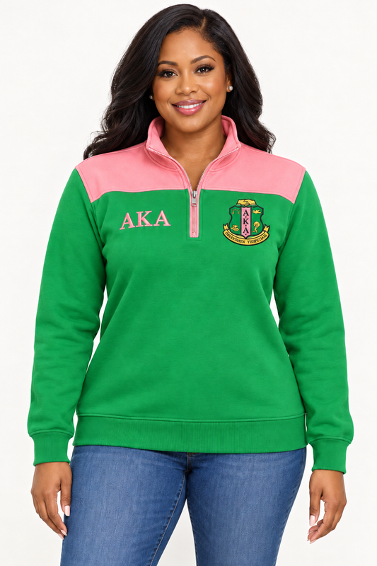 Black female model showing front of Alpha Kappa Alpha apple green quarter-zip with salmon pink shoulder panel