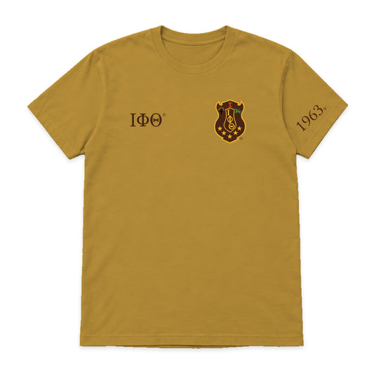 Digital product mockup: Iota Phi Theta gilded gold T-shirt with original brand-kit left-chest shield, small brown Greek letters and 1963 on wearer's left sleeve