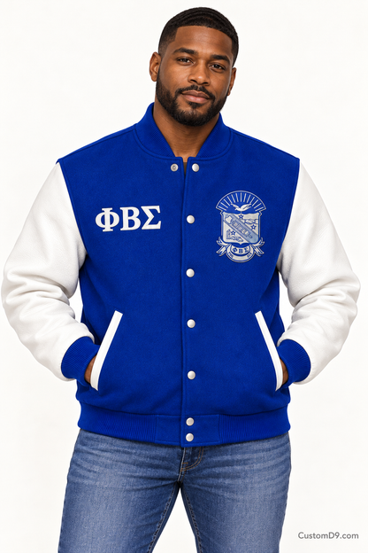 Black man modeling Phi Beta Sigma premium contrast varsity jacket with royal blue body and white sleeves, front view.