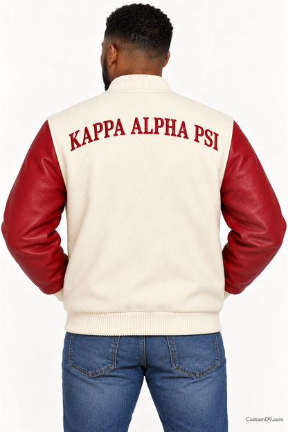 Black man modeling Kappa Alpha Psi premium contrast varsity jacket with cream body and crimson sleeves, back view.