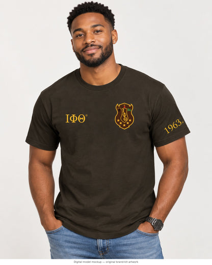 Digital model mockup: adult male wearing the charcoal brown Iota Phi Theta T-shirt; original shield, Greek letters and 1963 artwork directly composited from the brand kit