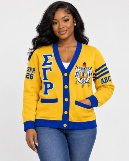 Black female model wearing Sigma Gamma Rho gold and royal blue embroidered cardigan