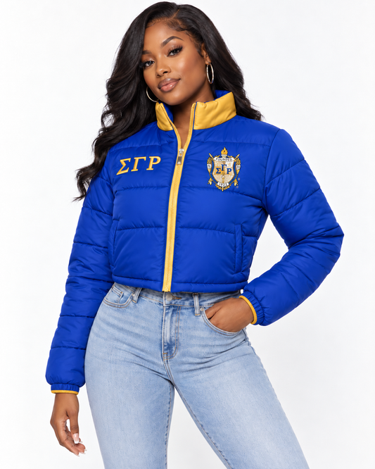 Sigma Gamma Rho royal blue cropped puffer jacket with gold trim and custom embroidery on female model