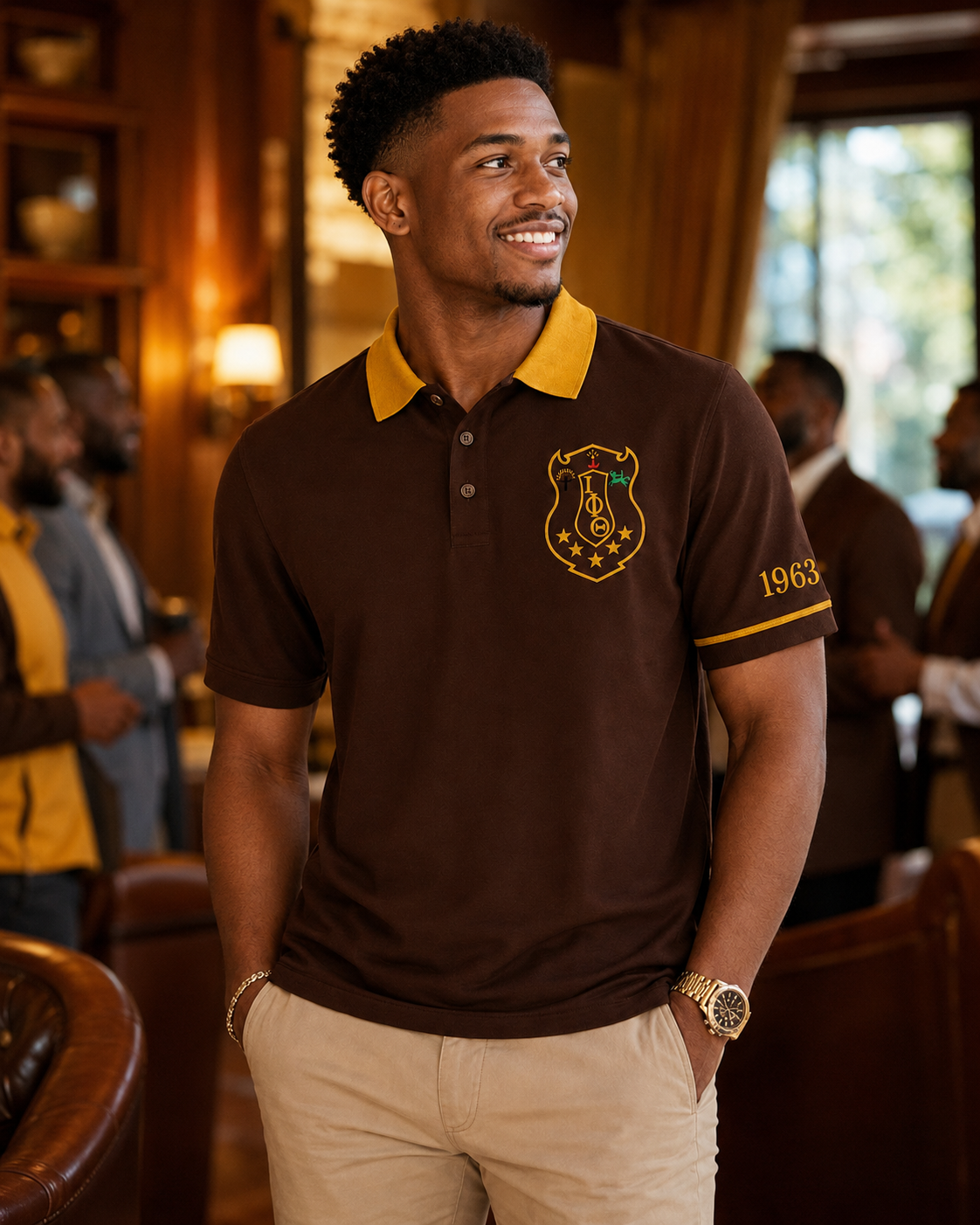 Lifestyle view of an Iota Phi Theta brown and gold embroidered polo