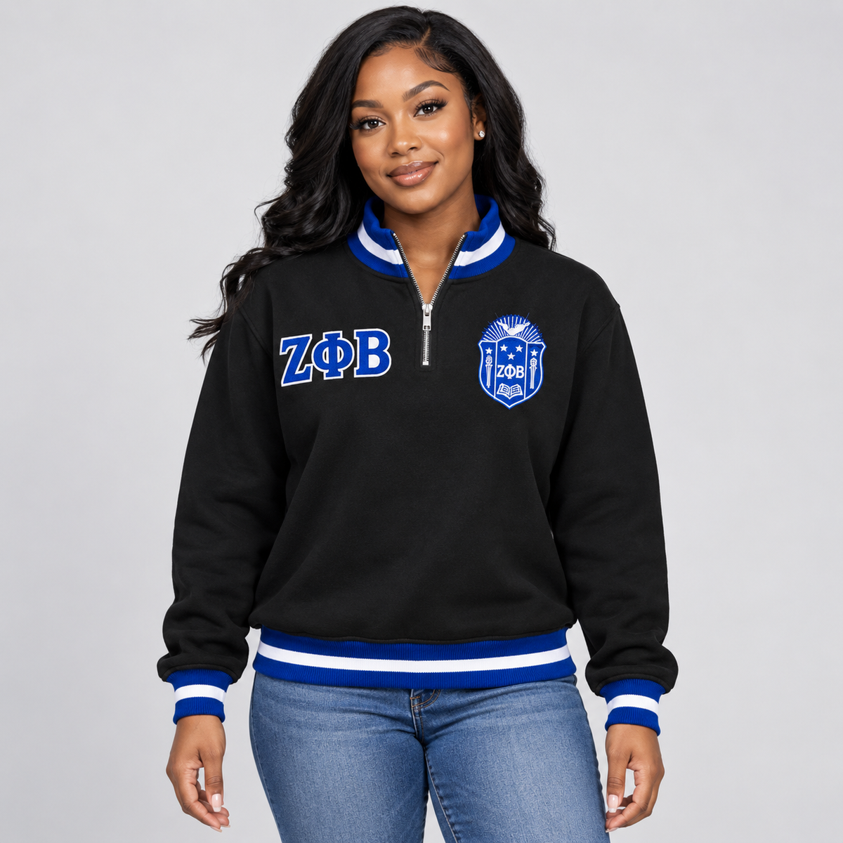 Black Zeta Phi Beta quarter-zip pullover with royal blue and white trim, embroidered crest and Greek letters on a female model