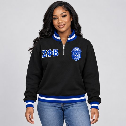Black Zeta Phi Beta quarter-zip pullover with royal blue and white trim, embroidered crest and Greek letters on a female model