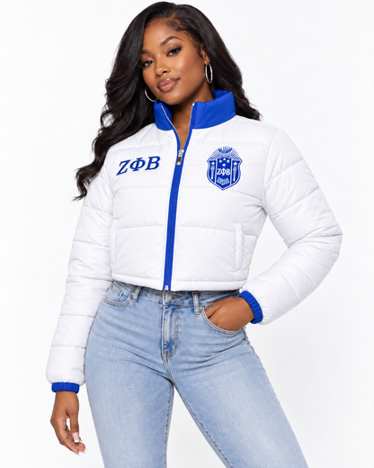 Zeta Phi Beta white cropped puffer jacket with royal blue trim and custom embroidery on female model